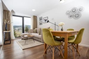 een woonkamer met een tafel en groene stoelen bij Vista Durmitor - luxury cabin in Žabljak