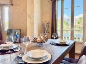 a dining room table with glasses and plates on it at Swiss Star - Easy Home Booking in Nice