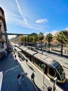 a train at a train station with people walking on the sidewalk at Swiss Star - Easy Home Booking in Nice