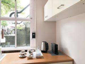 een aanrecht met een koffiezetapparaat en een raam bij KG House in Amsterdam