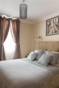 um quarto com uma cama grande e uma janela em Park Lane Apartments - Clarges Street em Londres