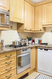 a kitchen with wooden cabinets and stainless steel appliances at Park Lane Apartments - Clarges Street in London
