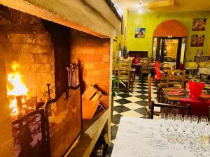 un restaurant avec une cheminée et une table avec des verres à vin dans l'établissement Logis Hotel Restaurant Le Grand Puech, à Mimet