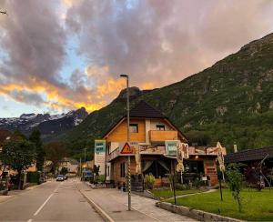 un edificio sul lato di una strada con montagne di Hostel Soča Rocks a Bovec