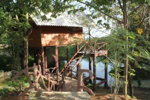 a house on the water with a bunch of trees at Treehouse Holidays-Lake View in Ko Yao Noi