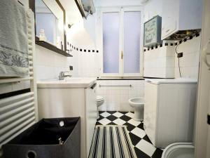 - une salle de bains blanche avec un sol en damier noir et blanc dans l'établissement CASA DEGLI INDORATORI ACQUARIO - GENOVABNB it, à Gênes