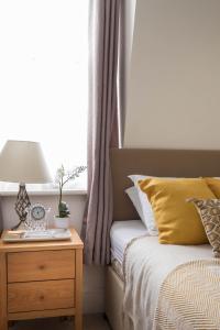 a bed with a night stand next to a window at Park Lane Apartments - Clarges Street in London