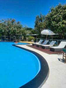 a swimming pool with lounge chairs and an umbrella at The Avenue in Whanganui