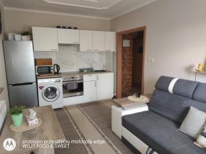 a living room with a couch and a kitchen at Apartament "Good Night" in Nowy Dwór Gdański +2 photos