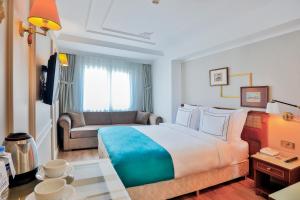 a hotel room with a large bed and a couch at Orient Express & Spa by Orka Hotels in Istanbul