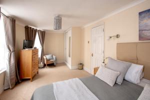 a bedroom with a bed and a dresser and a television at Park Lane Apartments - Clarges Street in London