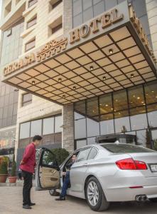 un homme sortant d'une voiture devant un hôtel dans l'établissement Gerasa Hotel, à Amman
