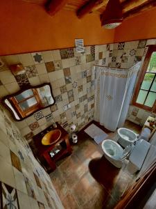 a bathroom with two sinks and a toilet and a tub at Luna de los Molles in Villa Las Rosas