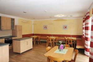 comedor con mesas y sillas y cocina en Exenbacher Hof - Pension, en Arnbruck