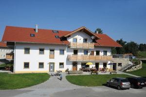 a large white building with a red roof at Exenbacher Hof - Pension in Arnbruck