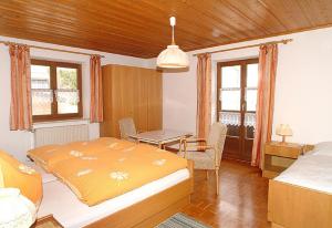 a bedroom with a bed and a table in it at Exenbacher Hof - Pension in Arnbruck