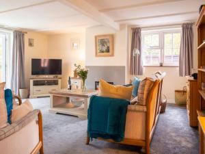 a living room with two chairs and a tv at Whippet Cottage in Evesham
