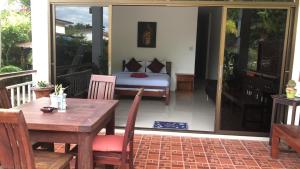 a room with a bed and a table and a table and chairs at Daisy's 2 bedroom family home for up to 5 guests with garden & BBQ in Ko Samed