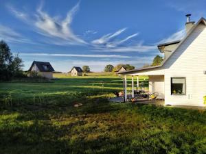 a white house with a field in the background at Chwila Pauzy in Tolkmicko