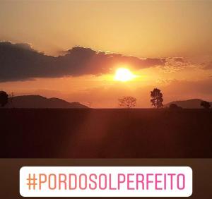 a sunset in a field with the wordsiopolispectici at Sítio são José in Piauí