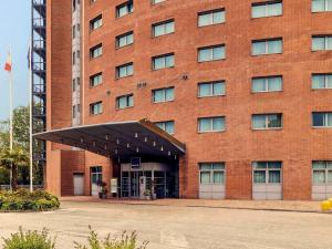 a large red brick building with an open door at Novotel Venezia Mestre Castellana in Mestre