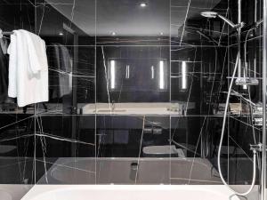 a bathroom with a shower and a bath tub at Sofitel London Gatwick in Horley