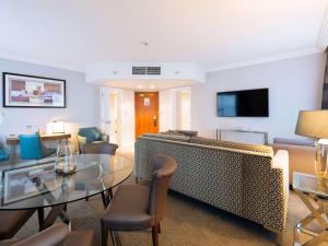 a living room with a glass table and chairs at Sofitel London Gatwick in Horley