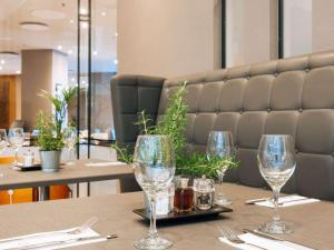 a table in a restaurant with wine glasses on it at Sofitel London Gatwick in Horley