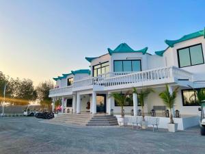 a large white house with a driveway at Pura Eco Retreat, Jubail Island in Abu Dhabi