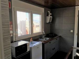 una pequeña cocina con fregadero y ventana en King Garfield House - Espaço de charme em Bragança, en Bragança