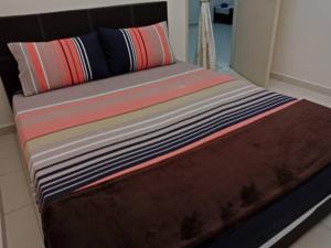 una cama con almohadas coloridas encima en Rumah Melaka, en Melaka