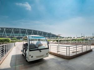 a small white golf cart driving on a bridge at Pullman Guangzhou Baiyun Airport in Guangzhou