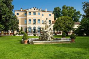 a statue in front of a large building at Best Western Plus Hotel Villa Tacchi in Gazzo