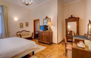 Schlafzimmer mit einem Bett, einer Kommode und einem Spiegel in der Unterkunft Best Western Plus Hotel Villa Tacchi in Gazzo