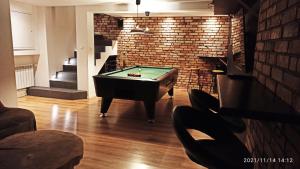 a room with a pool table and a brick wall at Willa Słubica in Bieniewice