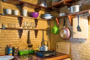 a kitchen counter with a stove and utensils at Treehouse Holidays-Lake View in Ko Yao Noi