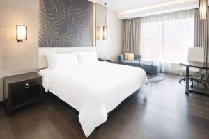マスカットにあるRadisson Collection Muscat, Hormuz Grandのホテルルーム内の大きな白いベッド