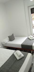 2 camas en una habitación con ordenador portátil. en H Noche y Dia, en Madrid