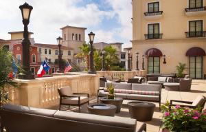 een hotelpatio met banken, stoelen en vlaggen bij Bluegreen Vacations Eilan Hotel and Spa, Ascend Resort Collection in San Antonio