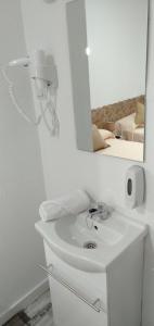 Baño blanco con lavabo y espejo en H Noche y Dia, en Madrid