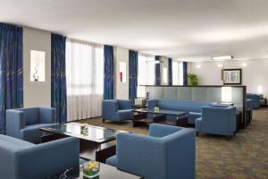 a waiting room with blue chairs and tables at Radisson Blu Hotel, Riyadh in Riyadh