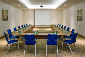 a conference room with a long table and blue chairs at Radisson Blu Hotel, Riyadh in Riyadh