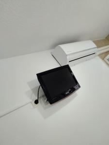 una pequeña televisión sentada en una mesa junto a una impresora en H Noche y Dia, en Madrid