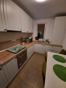 a kitchen with white cabinets and a table with chairs at Happy apartament in Sibiu