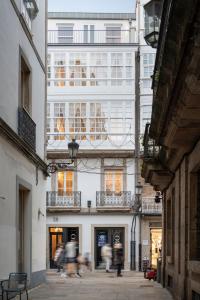 a group of people walking down a street in front of a building at housingcoruña REAL58 in A Coruña