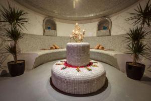 a white cake on a table in a room with plants at Park Inn by Radisson Dammam in Dammam