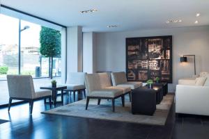 a lobby with chairs and a couch and a table at Park Inn by Radisson Antwerpen in Antwerp