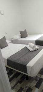 マドリードにあるHOSTAL Noche y Diaの部屋に並んで置かれた2つのベッド +19枚の写真