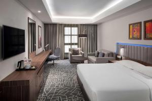 麦加Park Inn by Radisson Makkah Aziziyah的一间带床和客厅的酒店房间