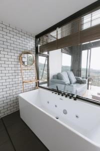 una vasca da bagno bianca in una stanza con finestra di Twins Farm Resort a Mae Salong